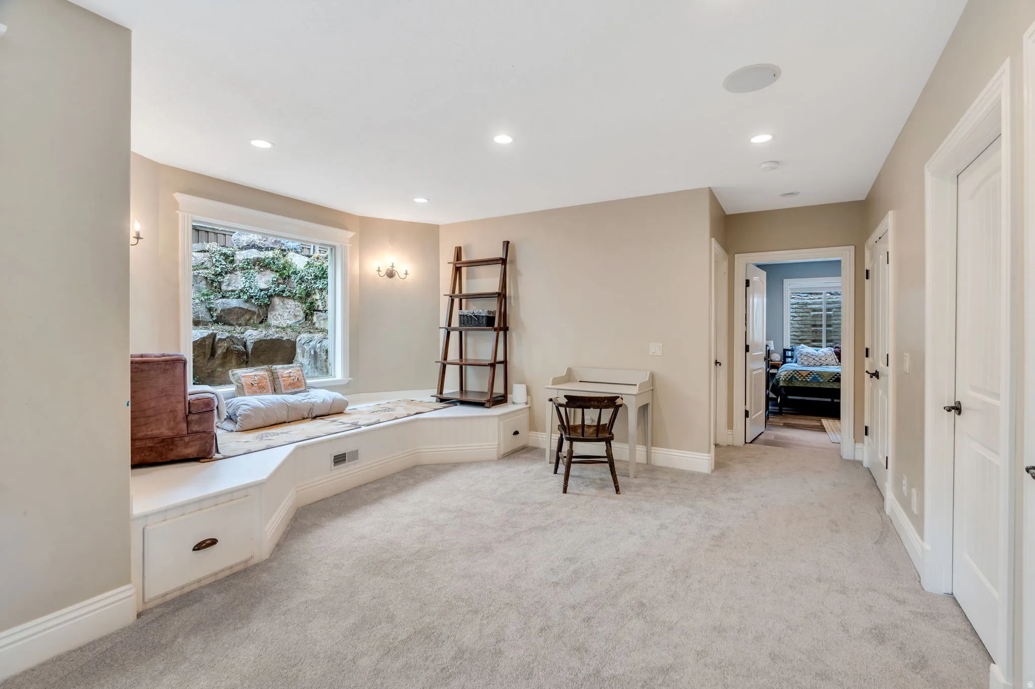 Sitting room with light colored carpet and recessed lighting