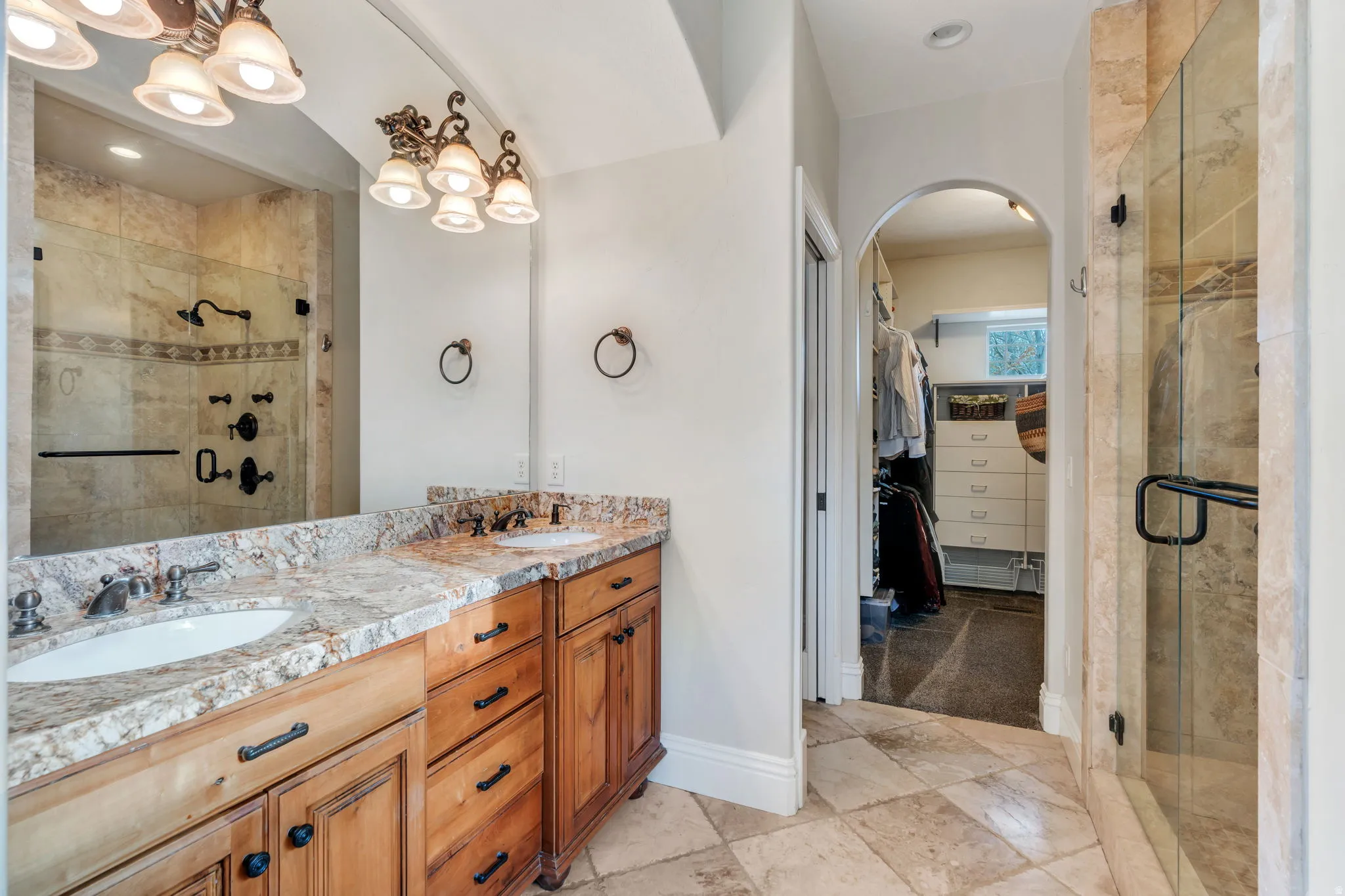 Bathroom with a spacious closet, a shower stall, and double vanity