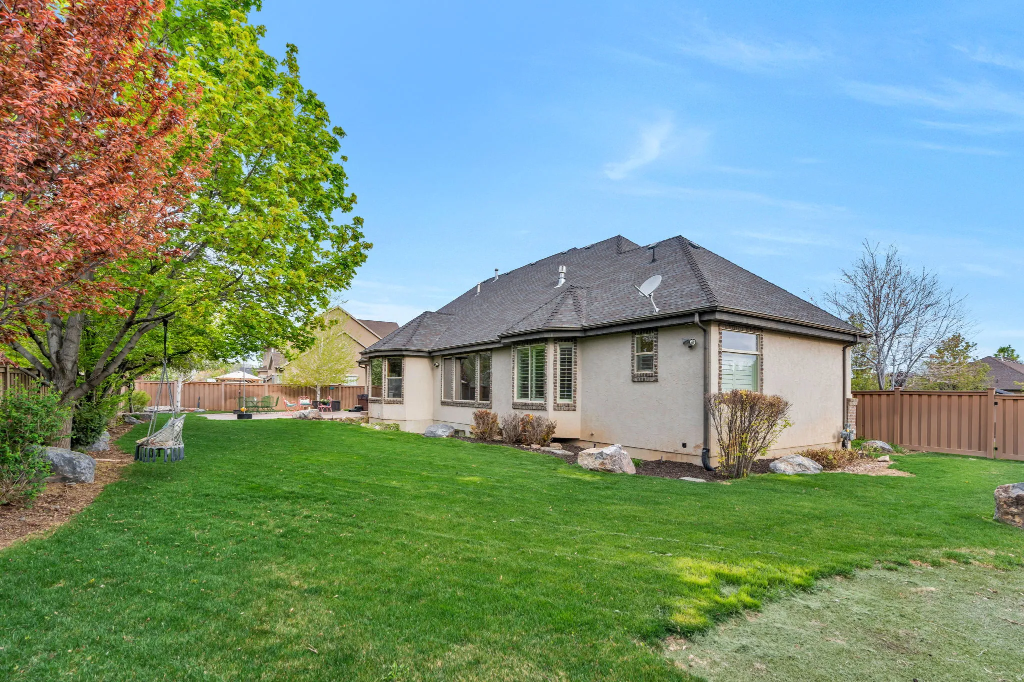 Rear view of house with a fenced backyard and stucco siding