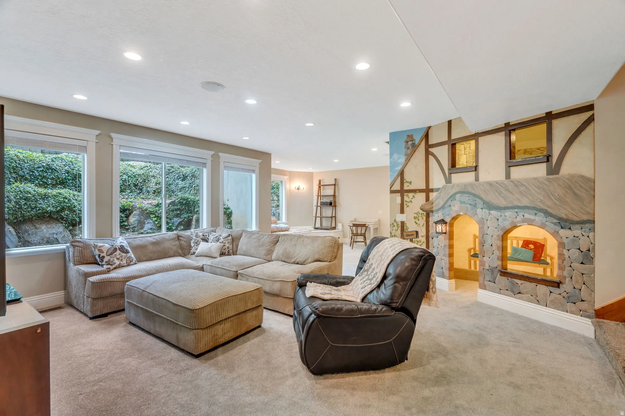 Living area with light colored carpet, recessed lighting, and arched walkways