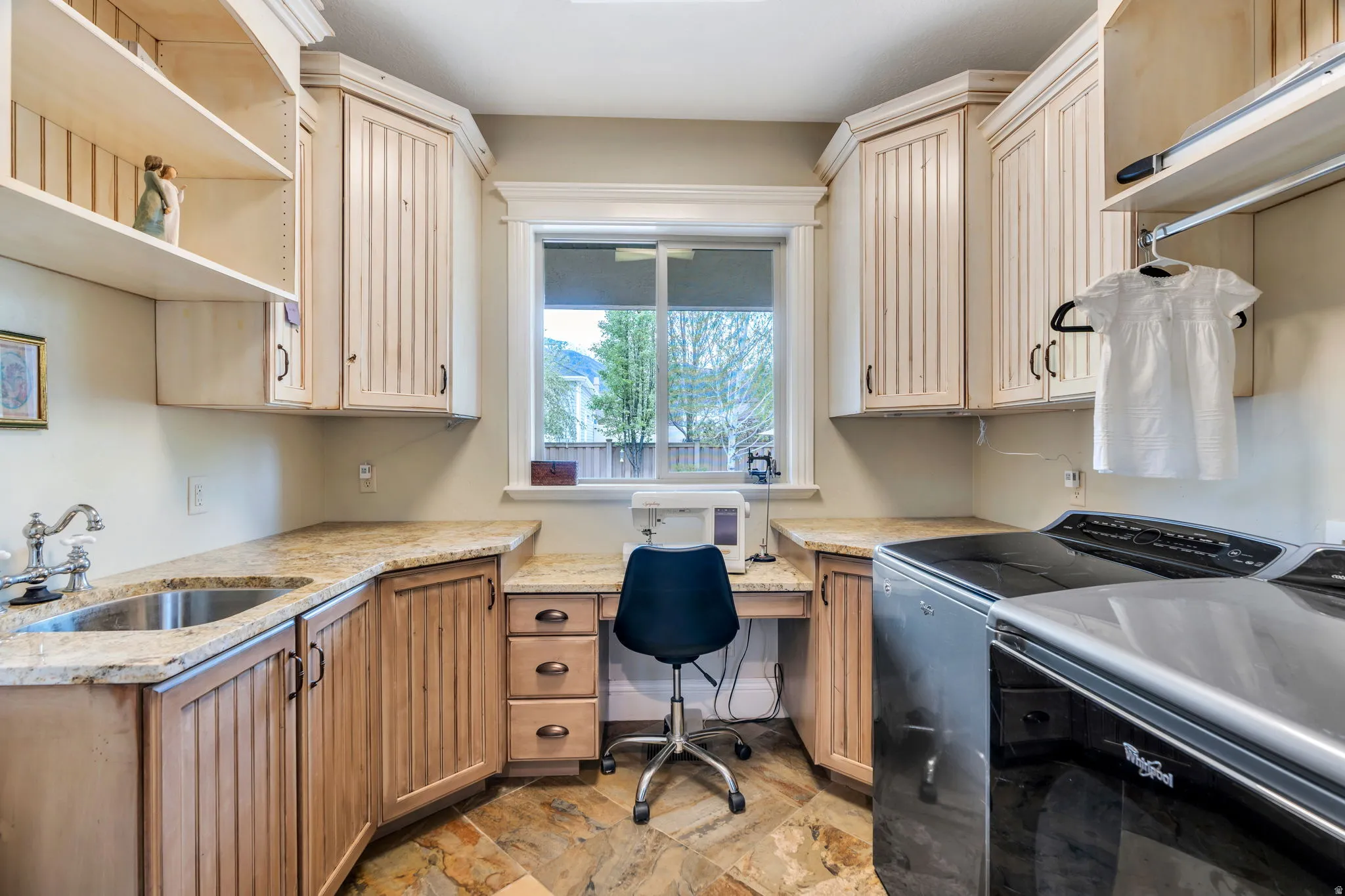 Laundry room featuring washing machine and dryer, stone finish flooring, and cabinet space