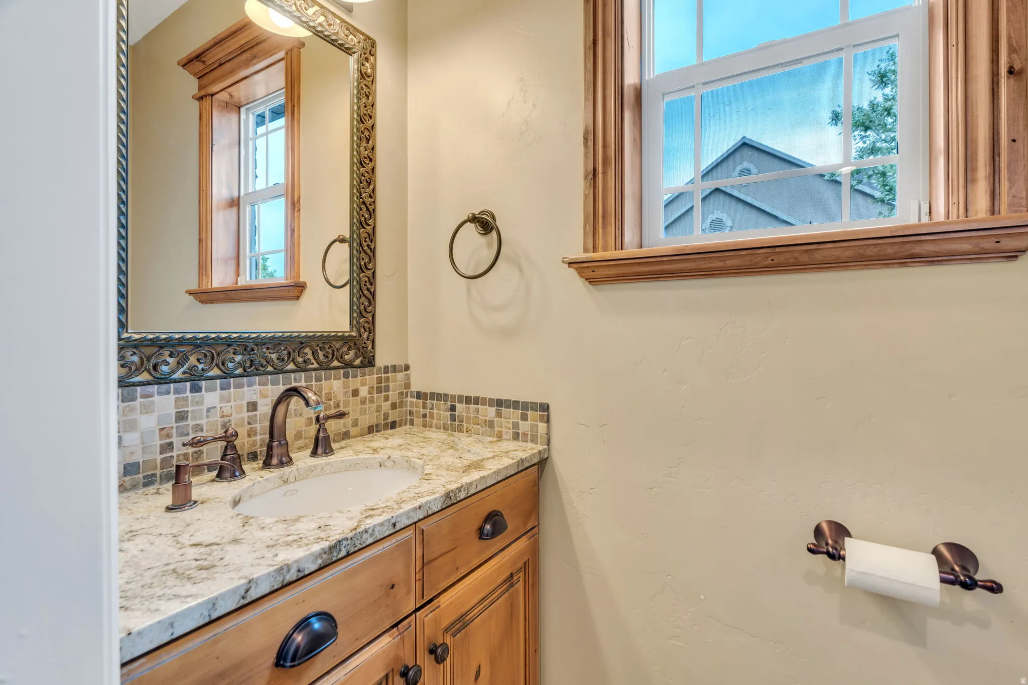 Bathroom featuring vanity and decorative backsplash