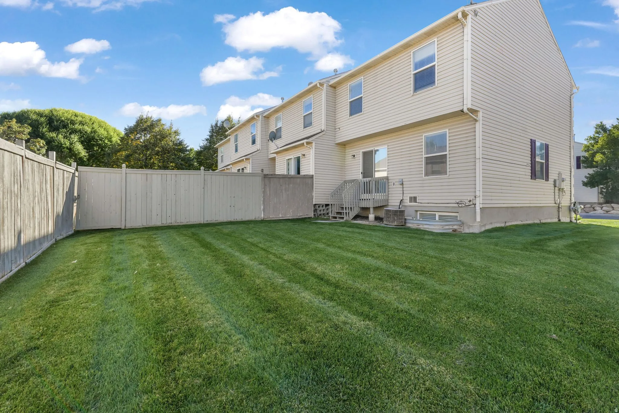 Back of house with a partial fenced backyard. HOA mows this entire area, unless you want to fence off and do it yourself.