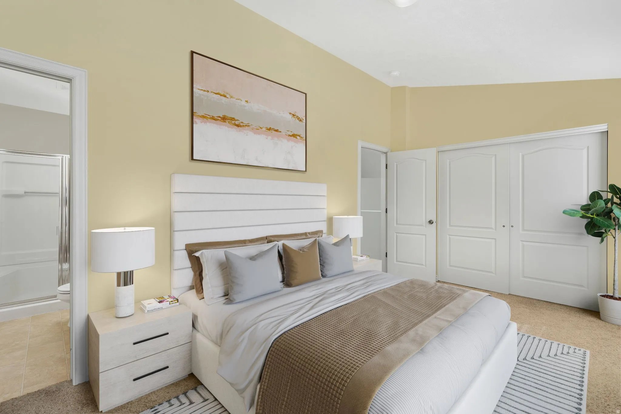 Primary/Master Bedroom with light carpet, ensuite bath, a closet, and lofted ceiling