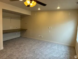 Carpeted room featuring a built-in counter space with shelving, a ceiling fan, and recessed lighting