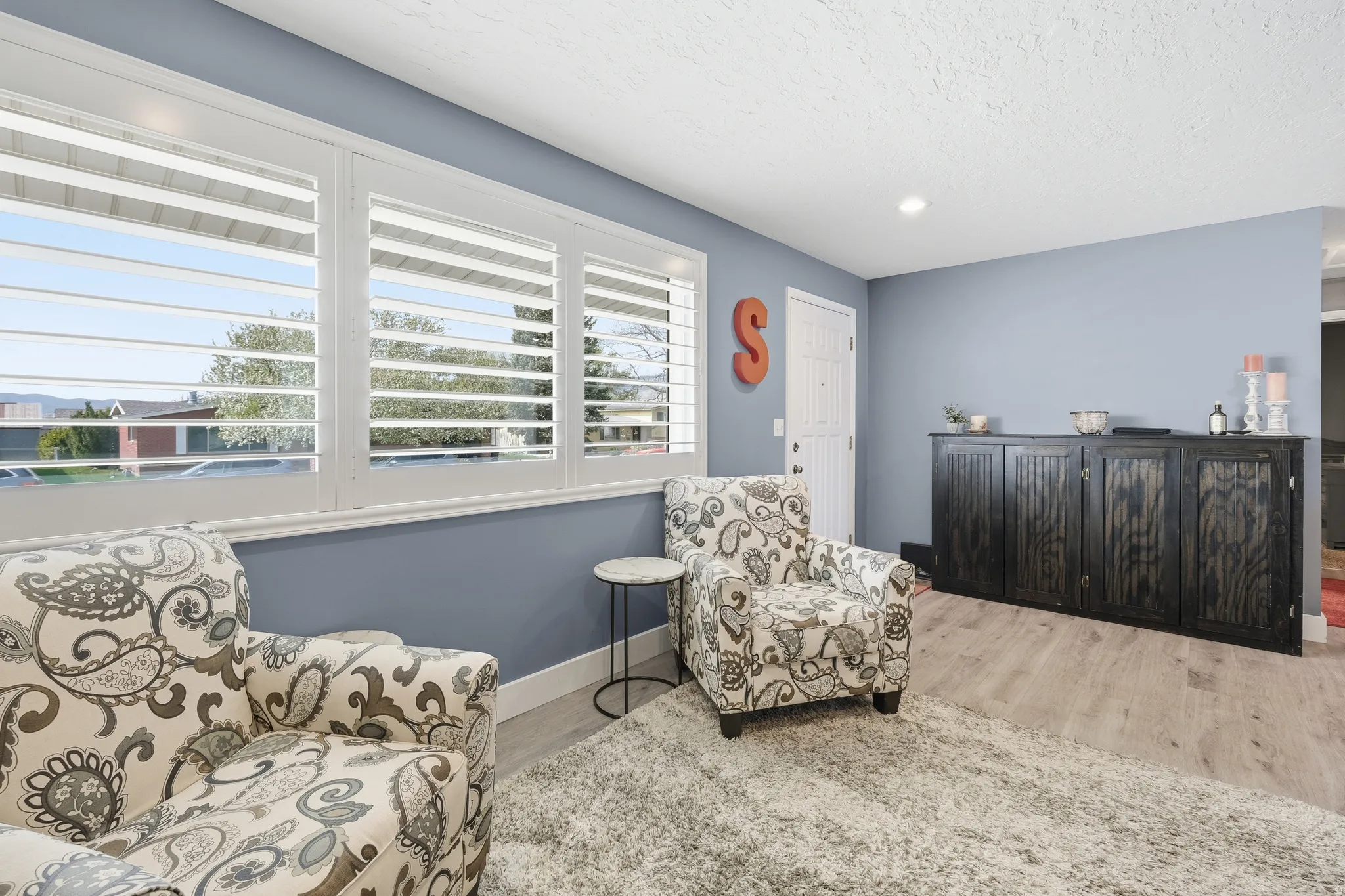 Living area featuring light wood-style floors, a textured ceiling, and recessed lighting