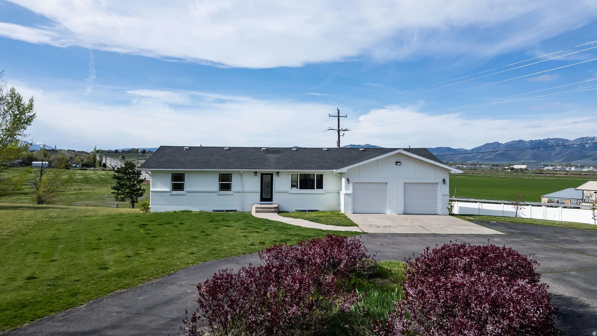 Single story home with concrete driveway, brick siding, roof with shingles, and a garage