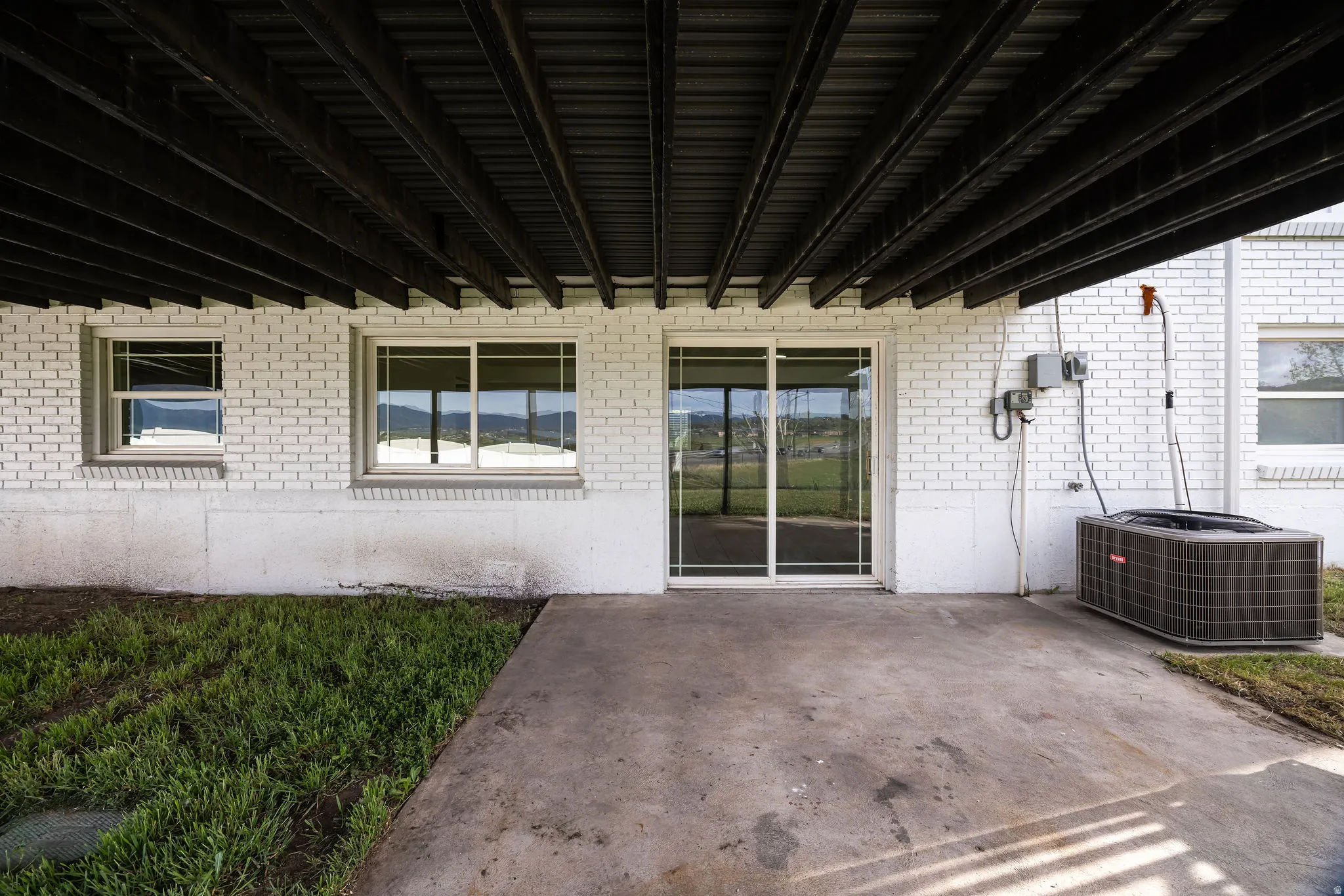 Entrance to property featuring a patio area and brick siding