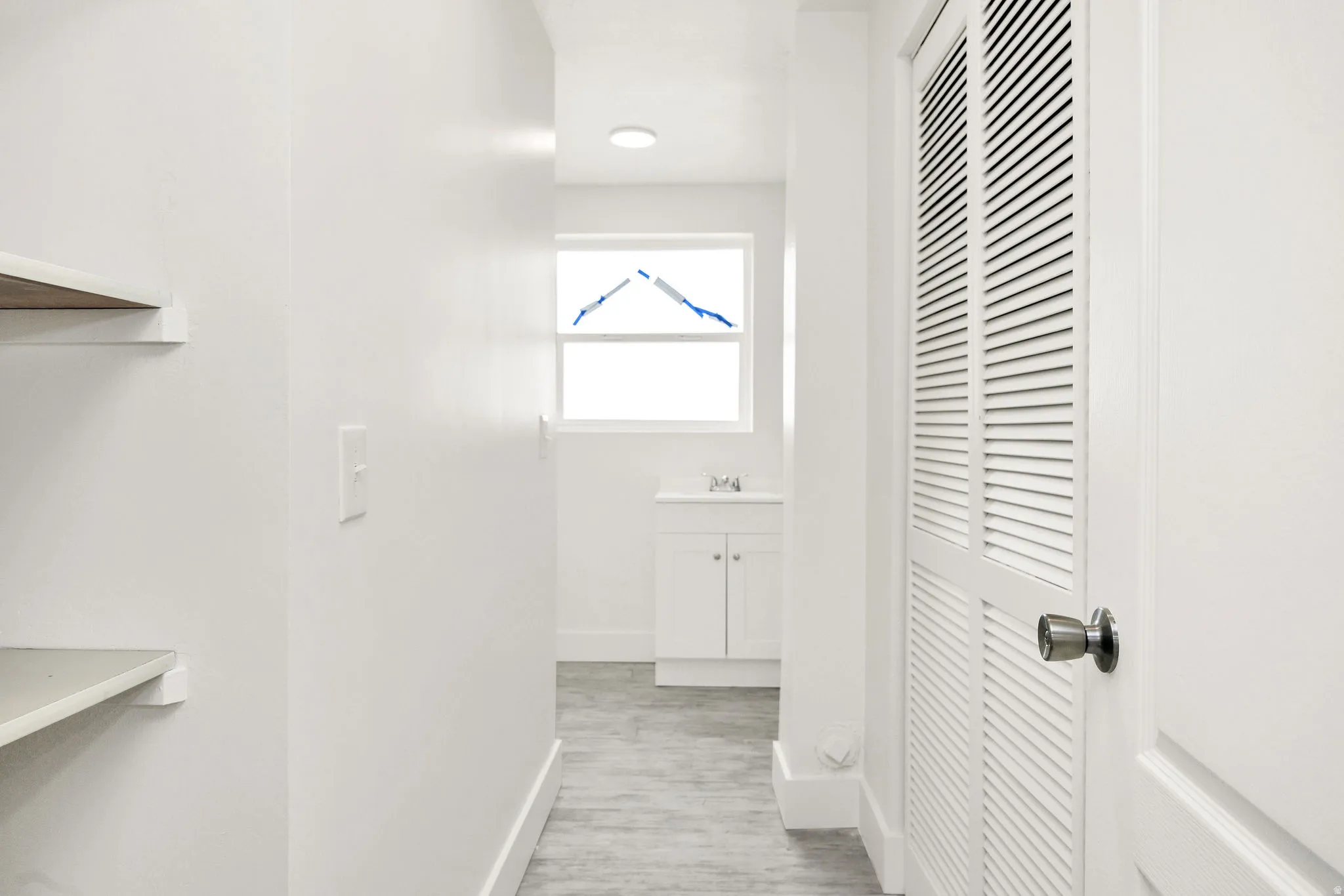 Corridor with baseboards and light wood-style flooring