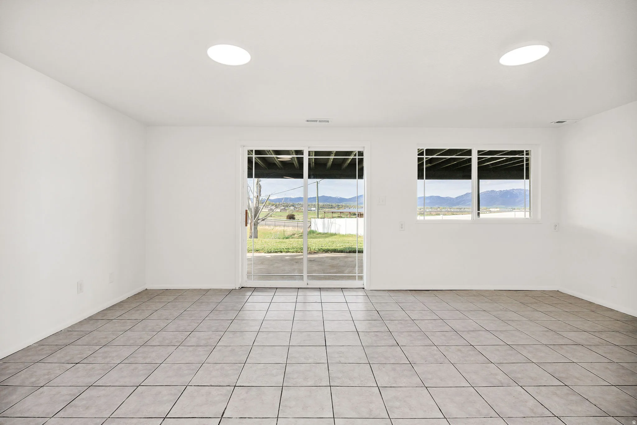 Empty room with a mountain view and light tile patterned floors