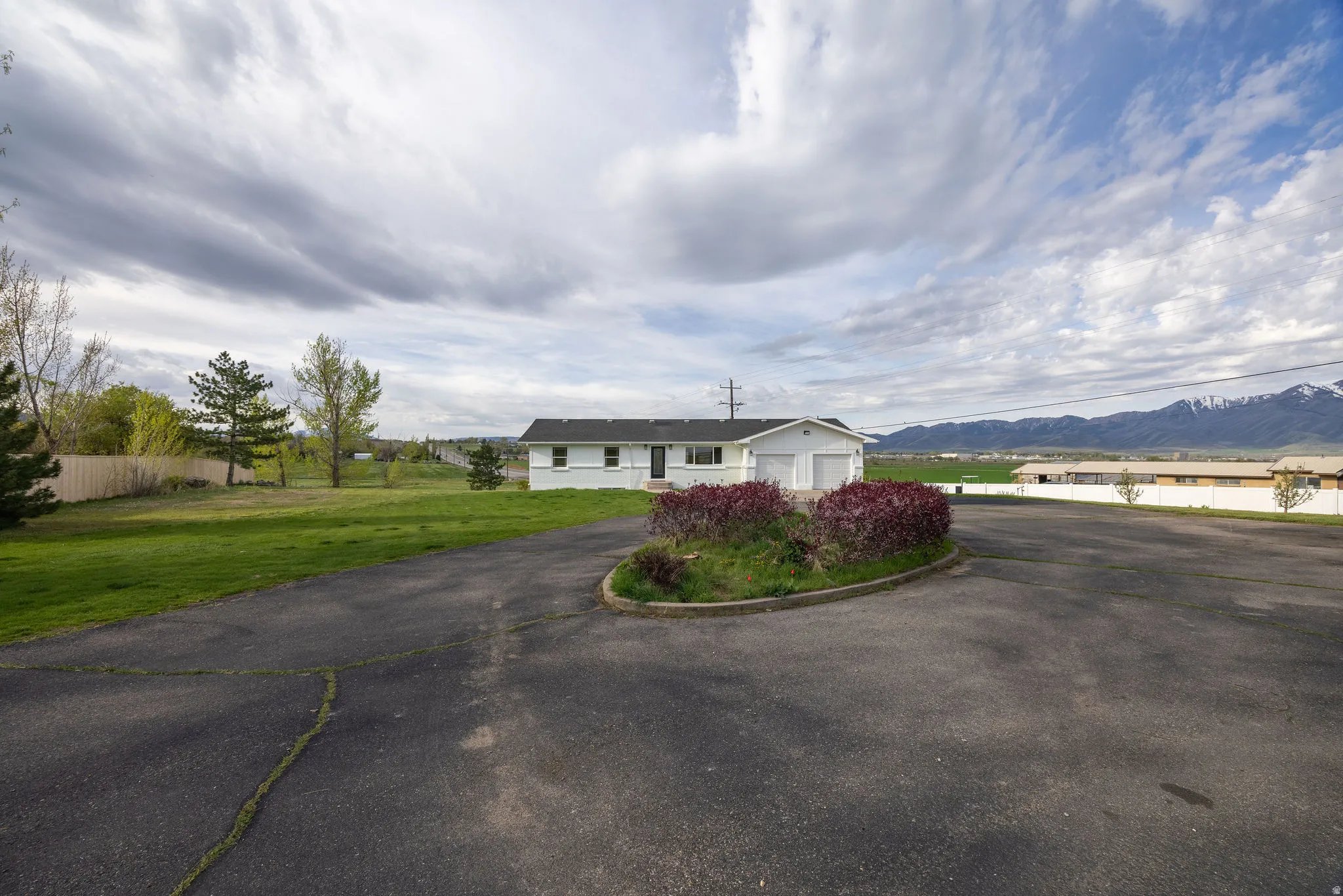Ranch-style home featuring a garage, a mountain view, and asphalt driveway