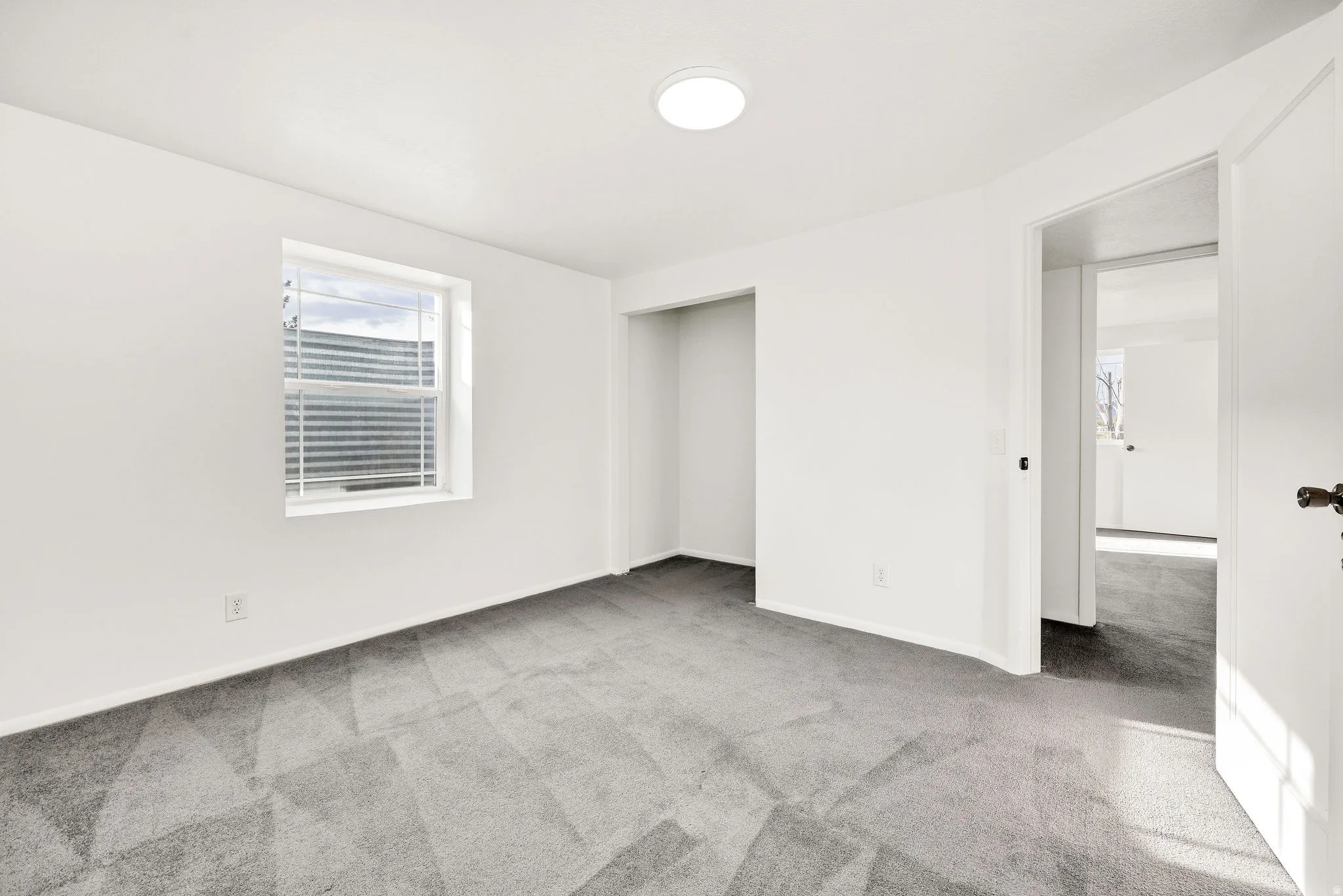 Empty room featuring light colored carpet and baseboards