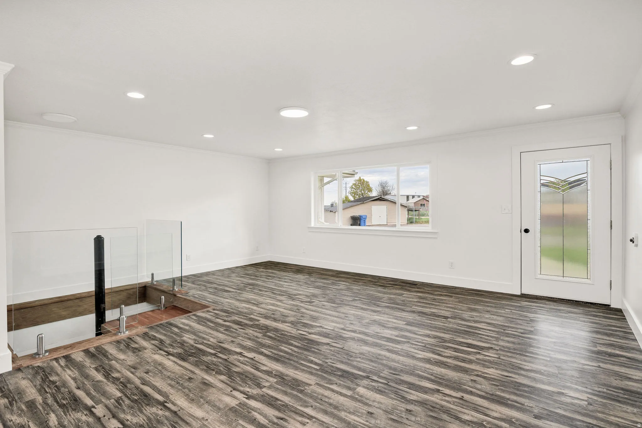 Unfurnished living room featuring dark wood finished floors, recessed lighting, and crown molding