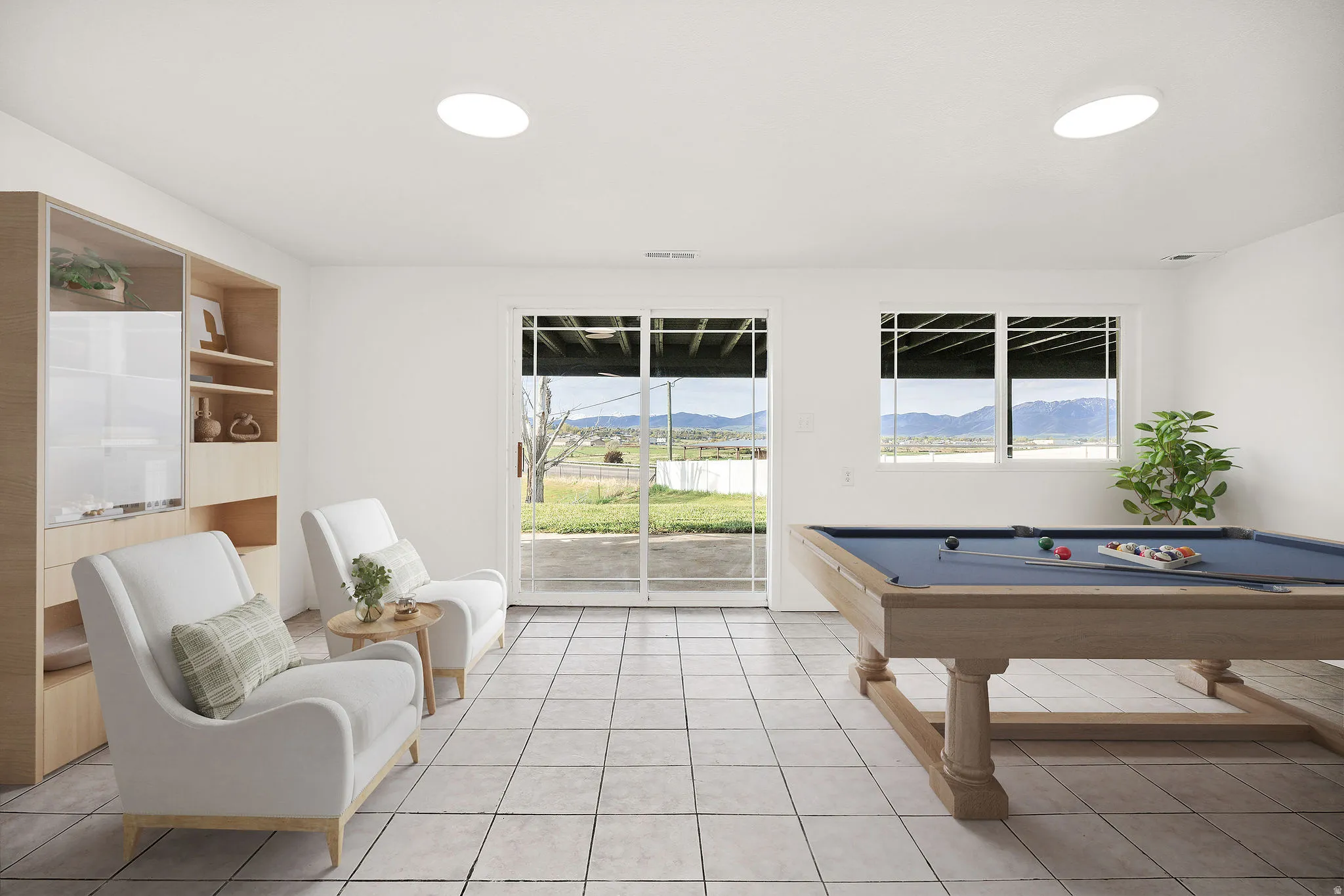 Virtually staged. Spacious room featuring light-toned tiled flooring, a built-in shelving unit with glass-fronted cabinets, and recessed ceiling lighting
