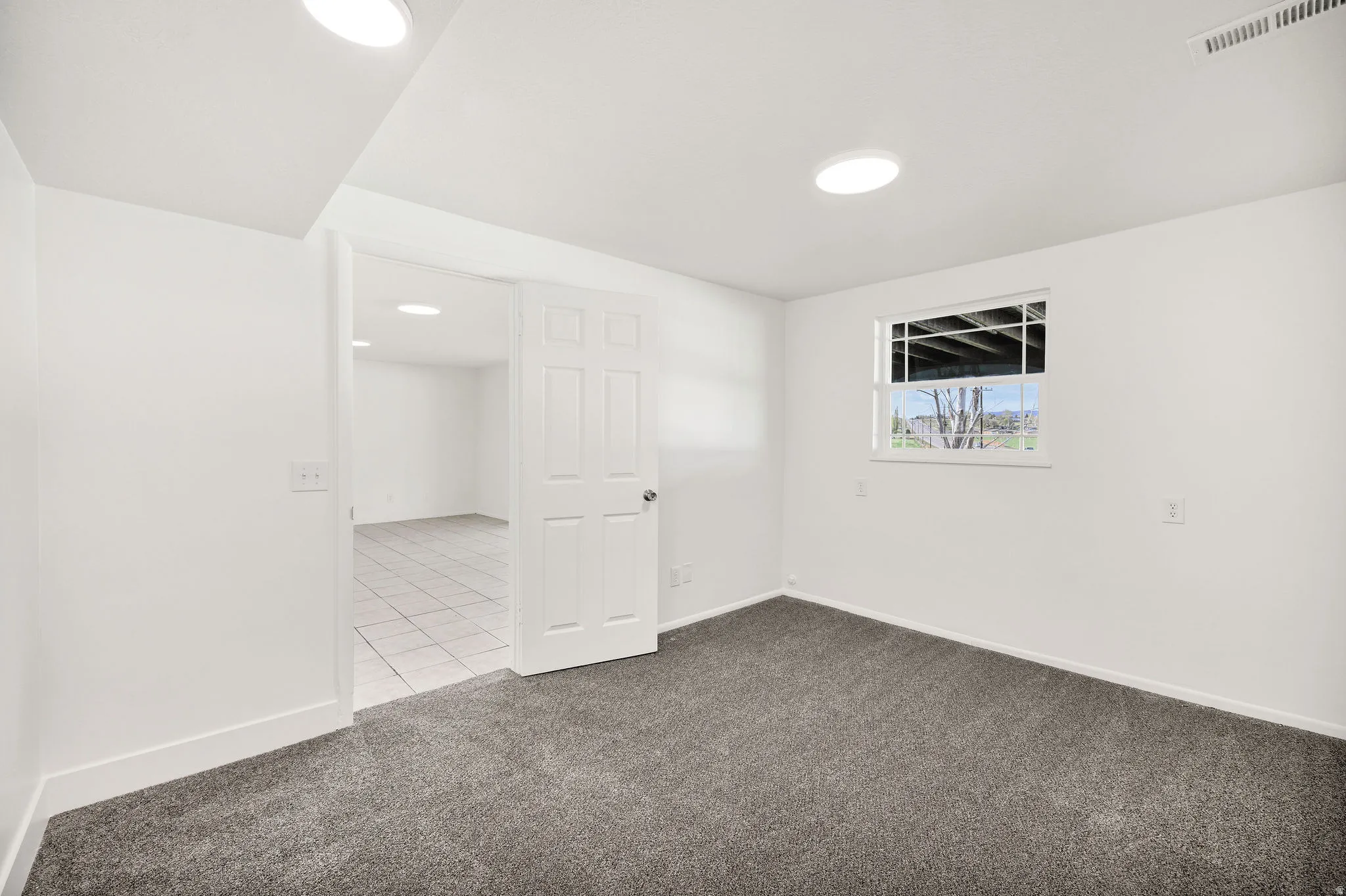 Empty room featuring dark colored carpet and baseboards