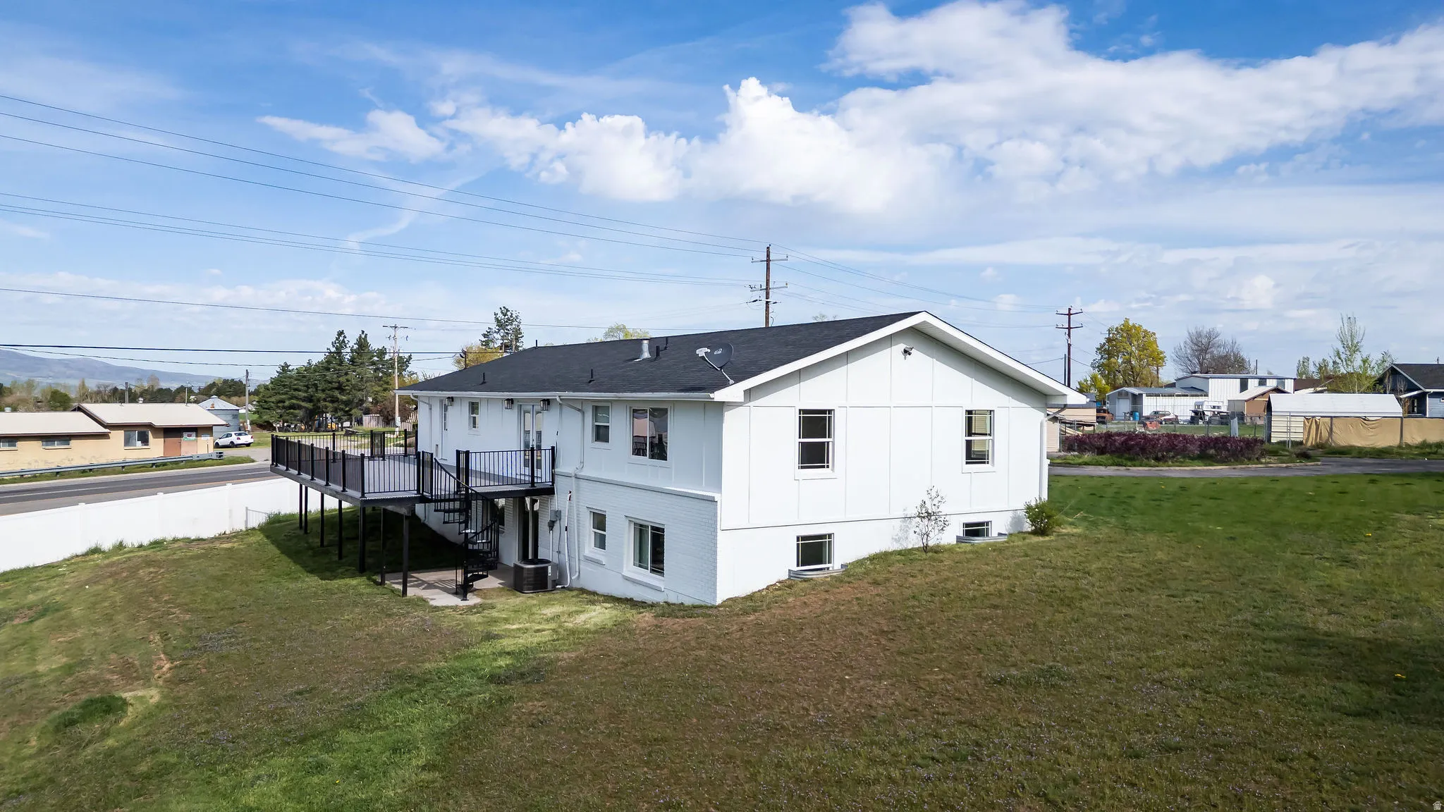 Rear view of property with a deck, a yard, board and batten siding, and a residential view