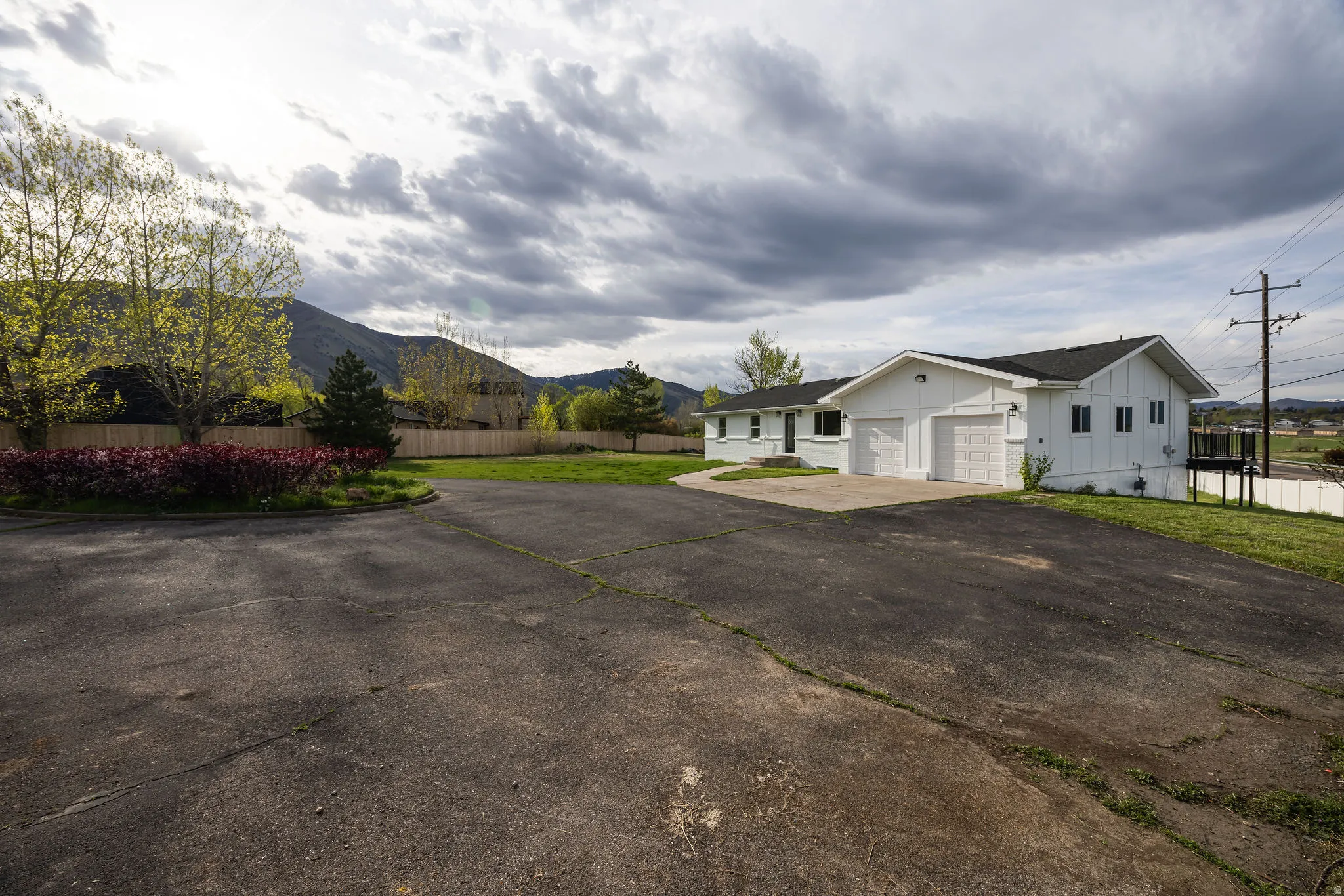 View of side of home with driveway, board and batten siding, a mountain view, and an attached garage