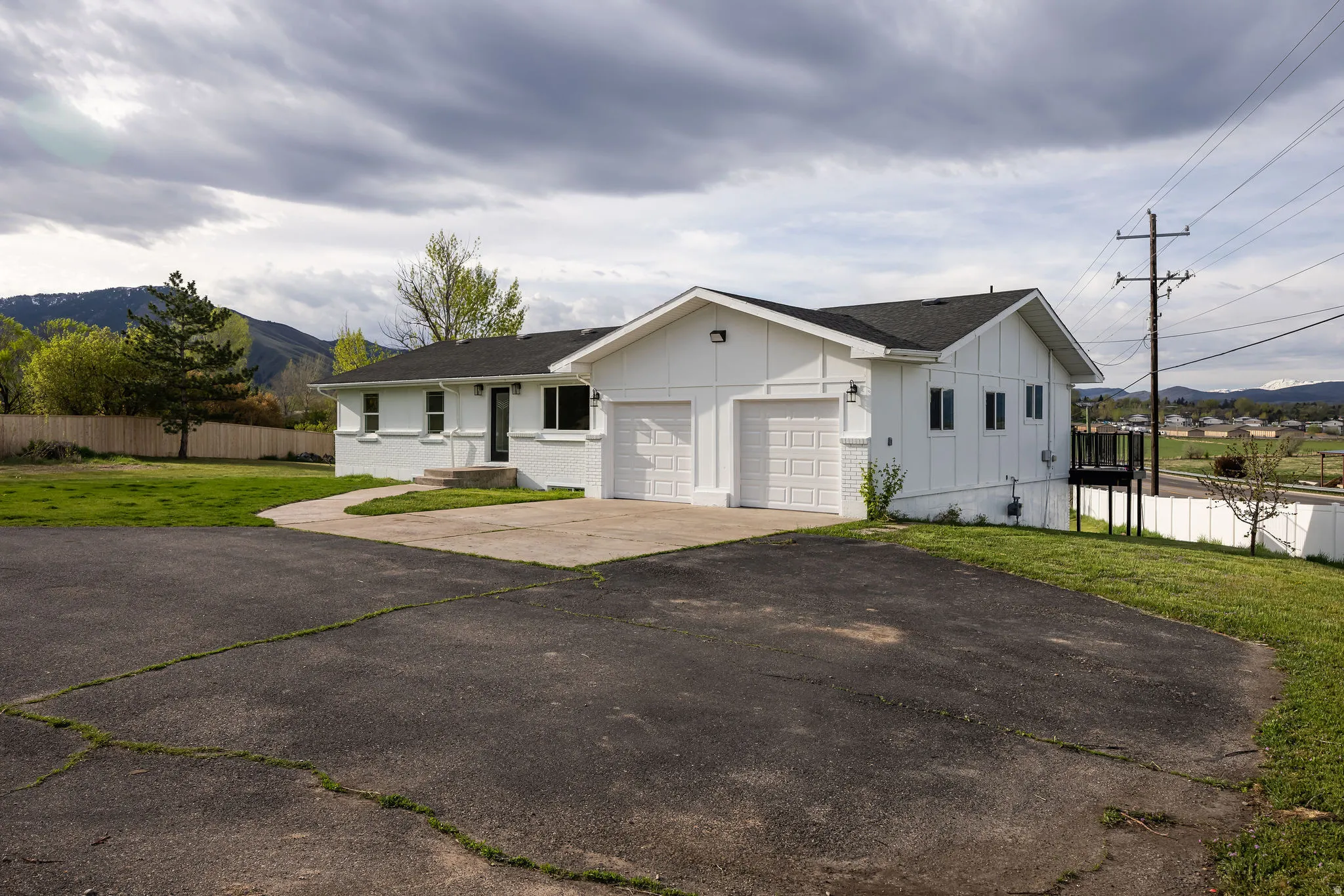 View of front of home with board and batten siding, a shingled roof, driveway, a garage, and a mountain view