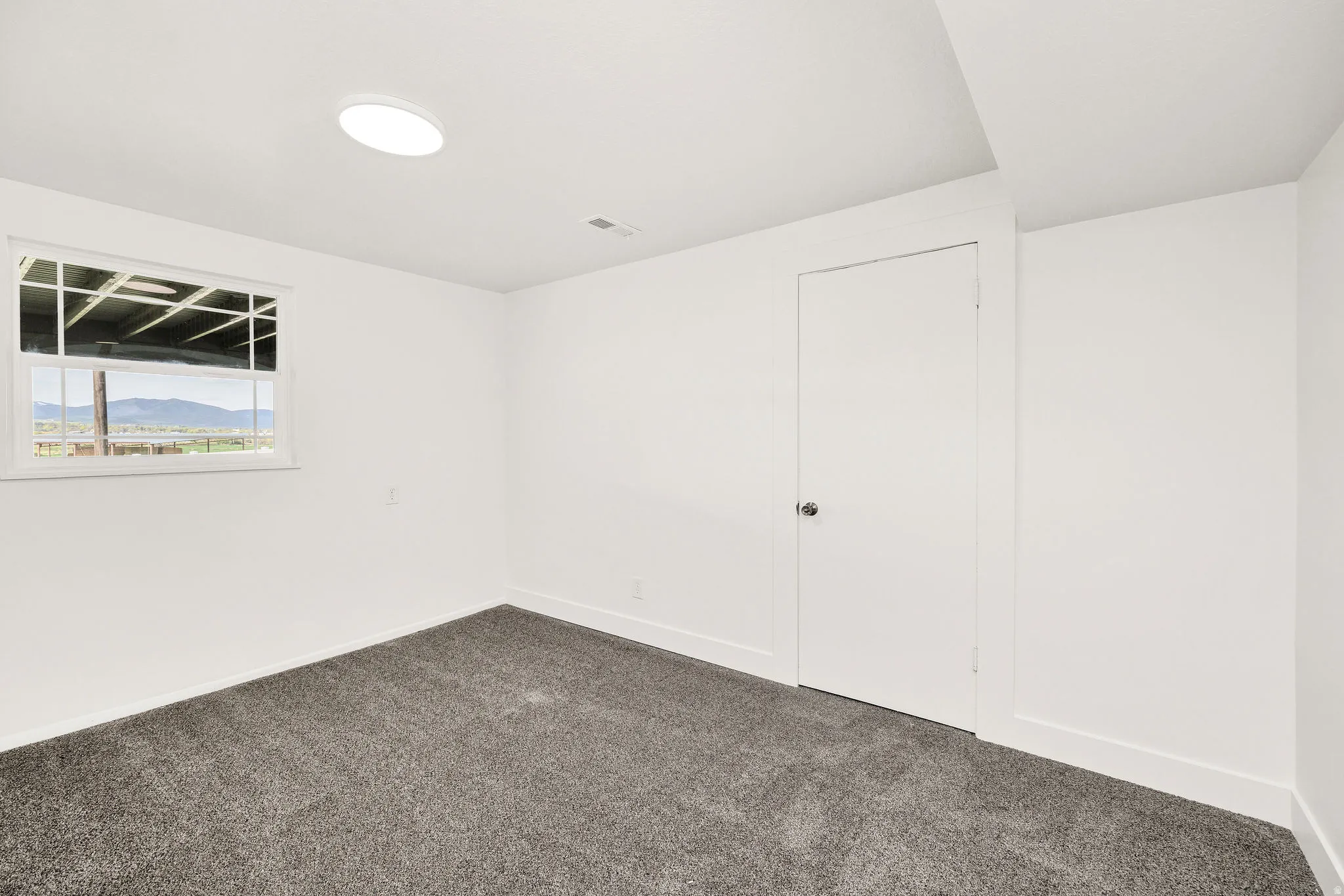 Empty room with baseboards and dark colored carpet