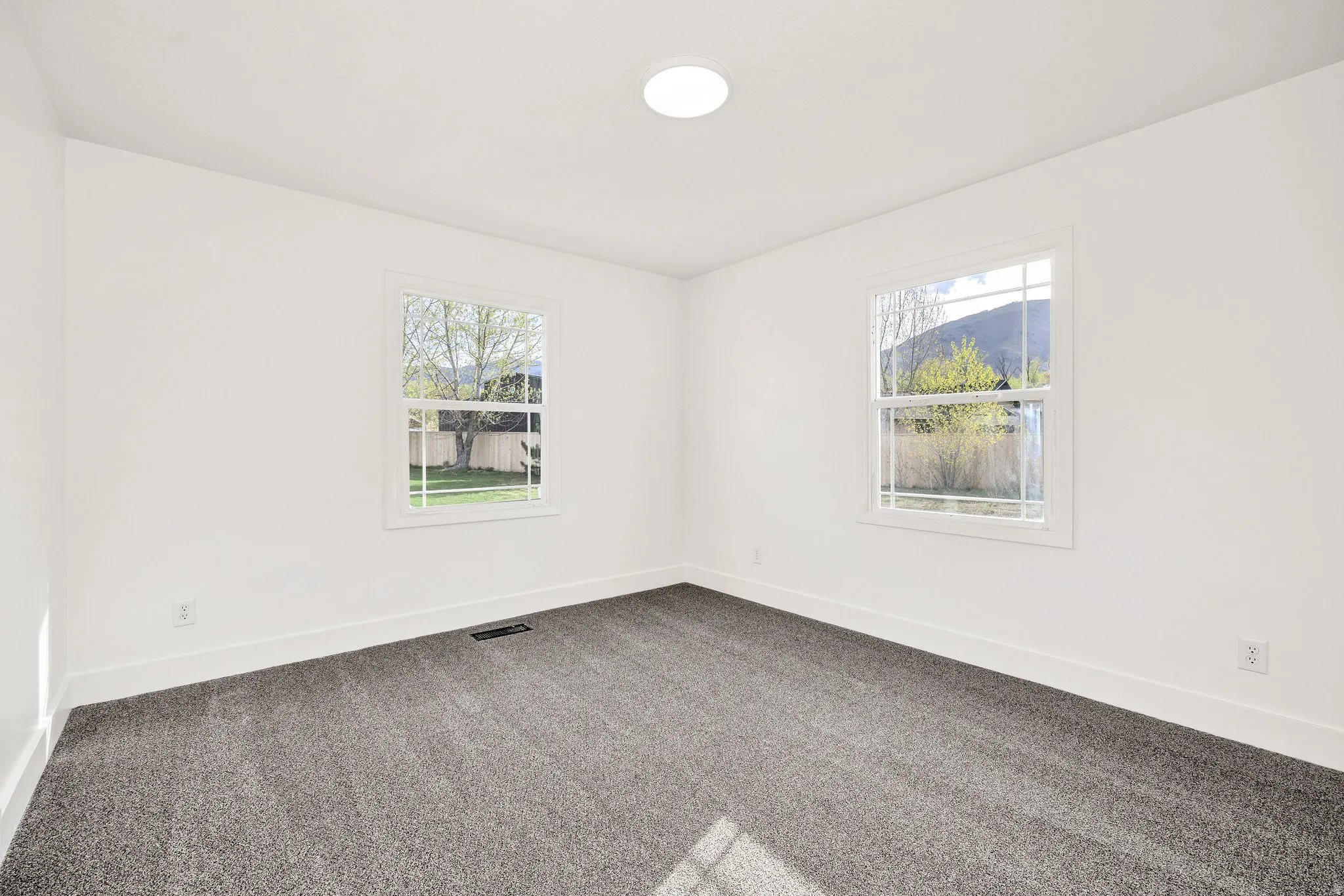 Spare room with dark colored carpet and healthy amount of natural light