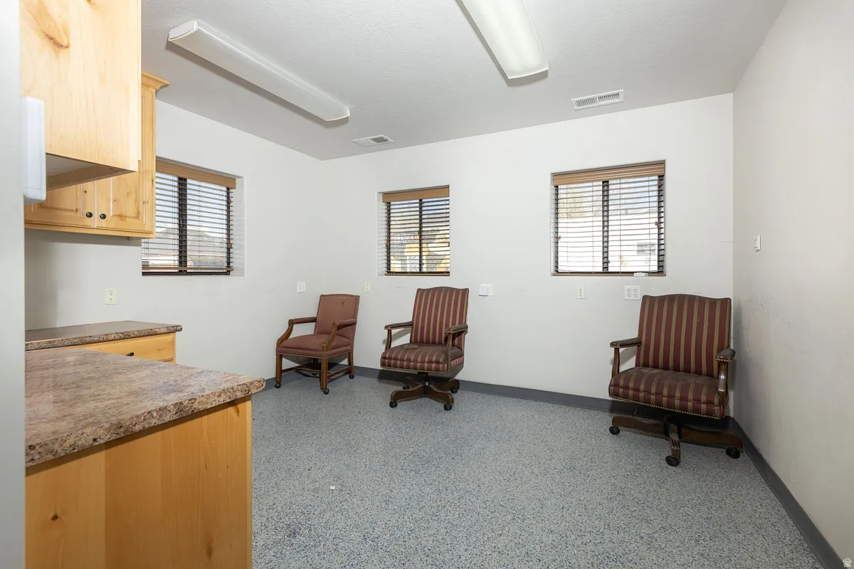 Sitting room featuring baseboards and dark aggregate flooring