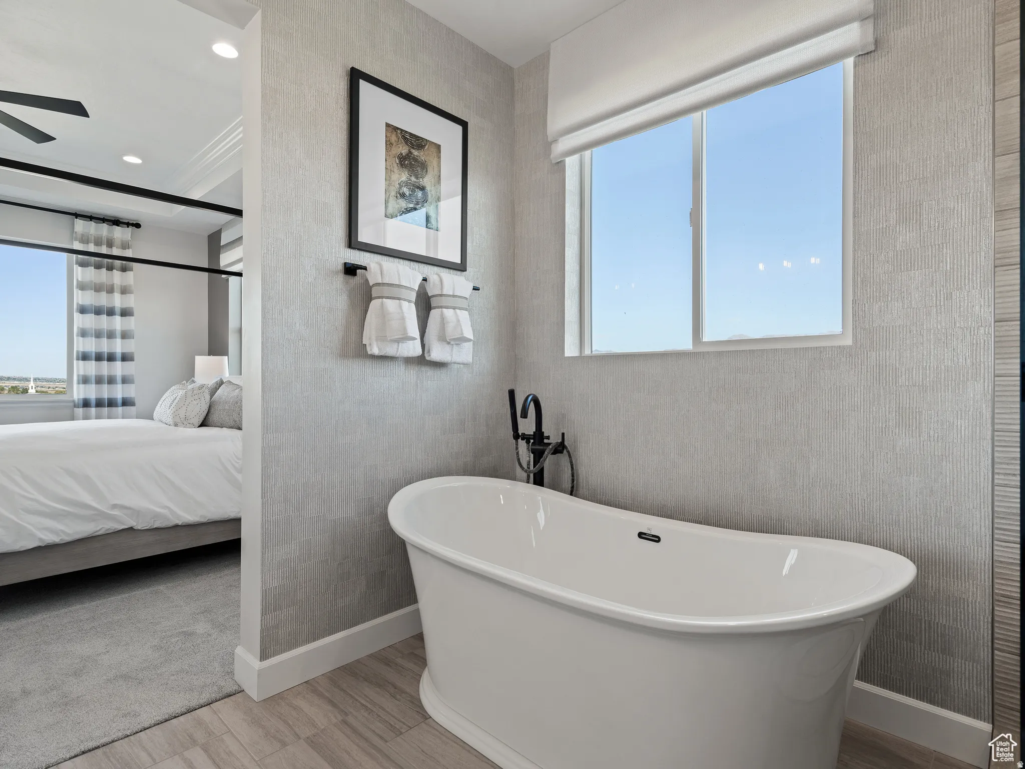 Full bath featuring a freestanding tub, ensuite bathroom, and light wood-style floors