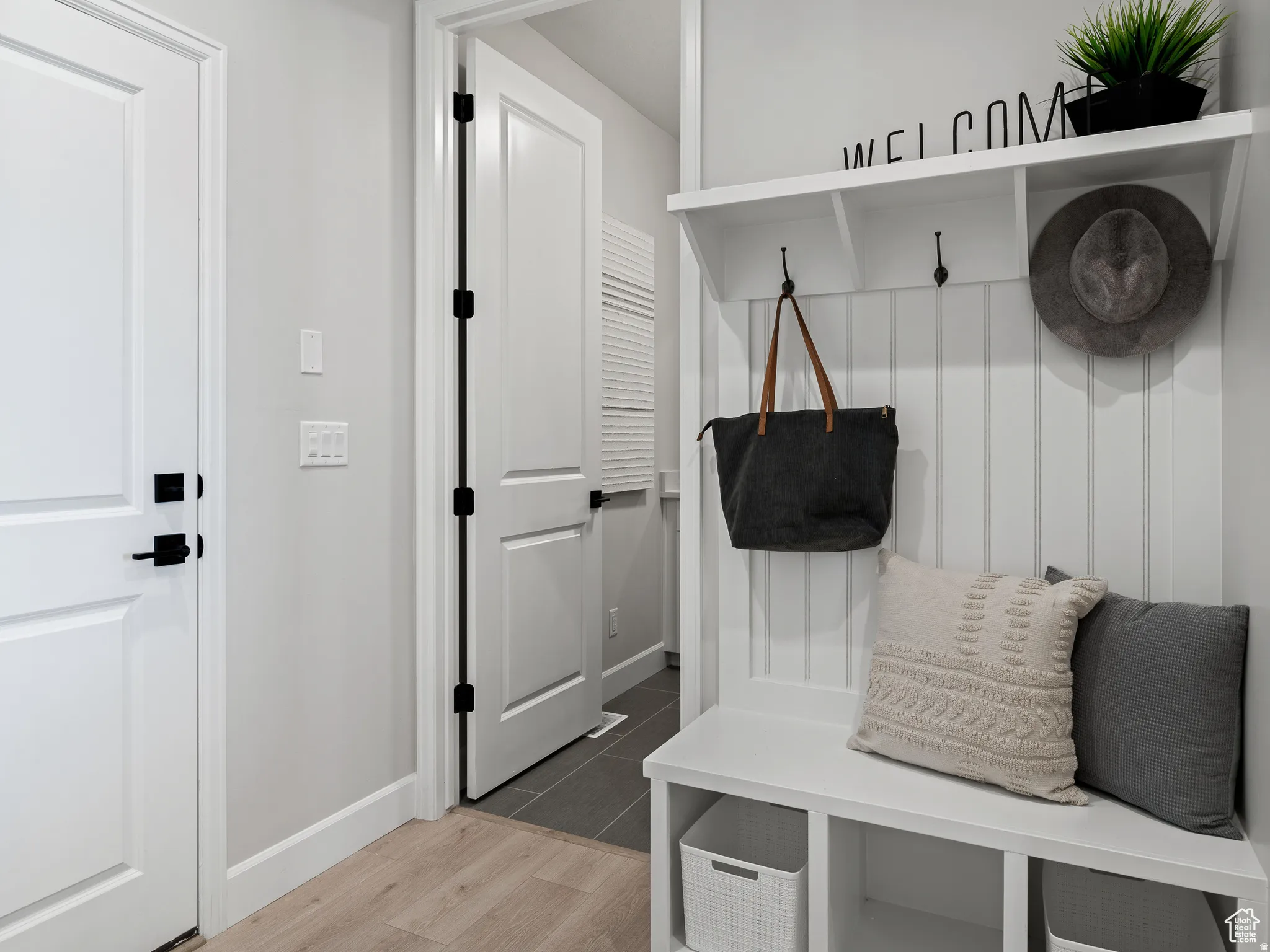 Mudroom featuring light wood-style flooring and baseboards