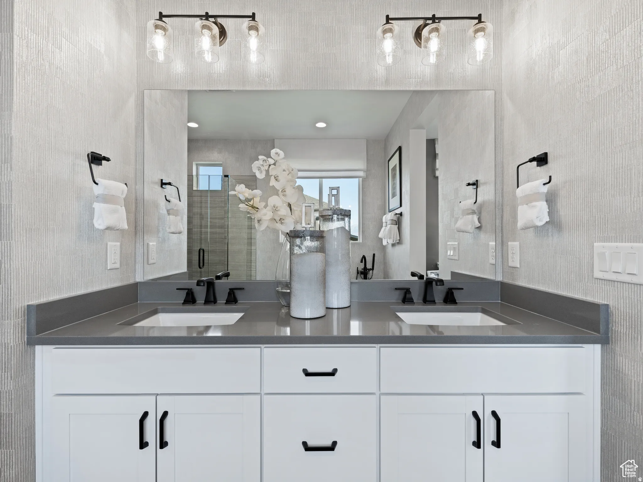 Full bath featuring a shower stall and double vanity