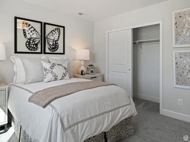 Carpeted bedroom with baseboards and a closet