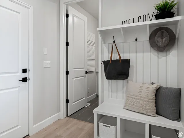 Mudroom featuring light wood-style flooring and baseboards