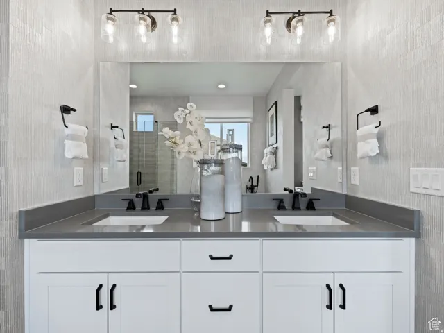 Full bath featuring a shower stall and double vanity