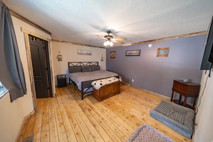 Bedroom featuring light wood-style floors, ceiling fan, and a textured ceiling