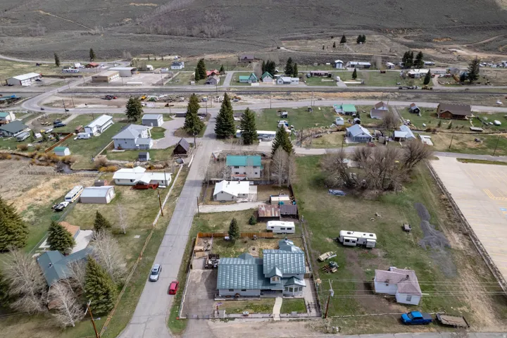 Aerial view of property and surrounding area featuring nearby suburban area