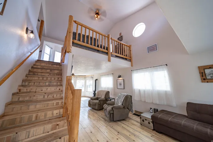 Stairs featuring a ceiling fan, healthy amount of natural light, a high ceiling, and hardwood / wood-style flooring