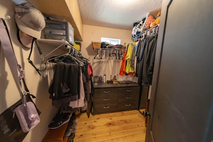 Walk in closet with light wood-style flooring