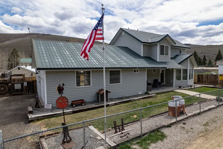 Back of property with a fenced backyard, a metal roof, and a patio
