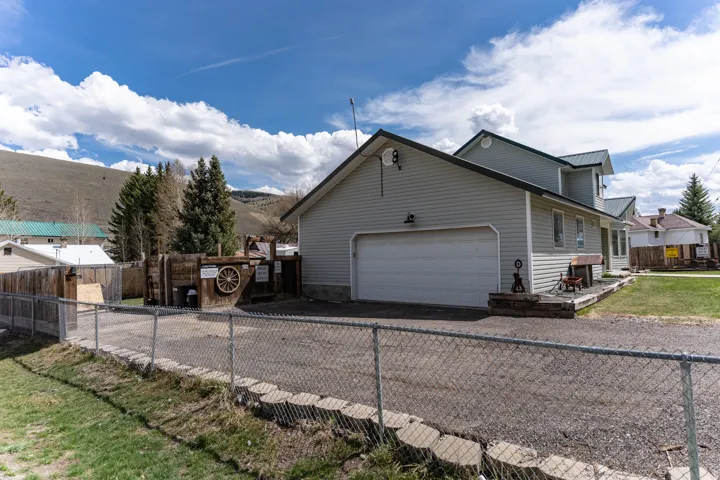View of home's exterior featuring asphalt driveway, a metal roof, and a garage