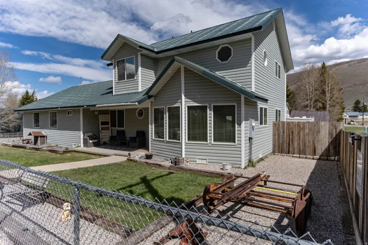 View of front of home with a fenced backyard, a metal roof, and a patio area