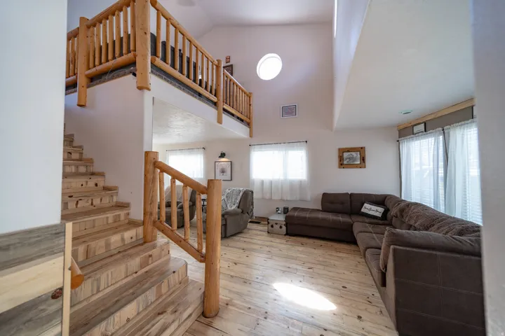 Living room featuring light wood-type flooring and lofted ceiling