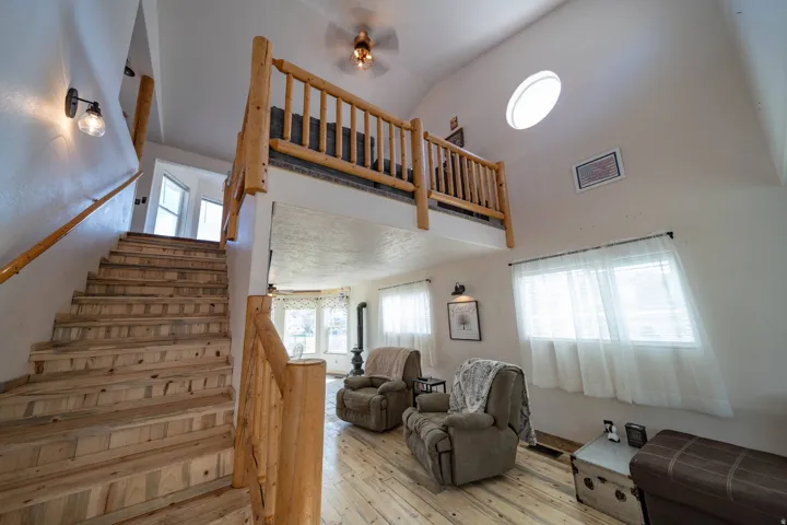 Stairway featuring ceiling fan, hardwood / wood-style floors, and a high ceiling