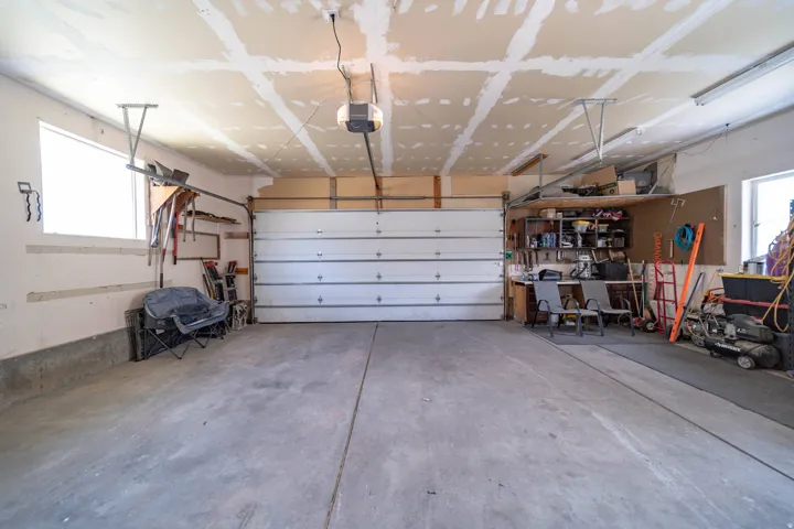 Garage featuring a garage door opener and a workshop area