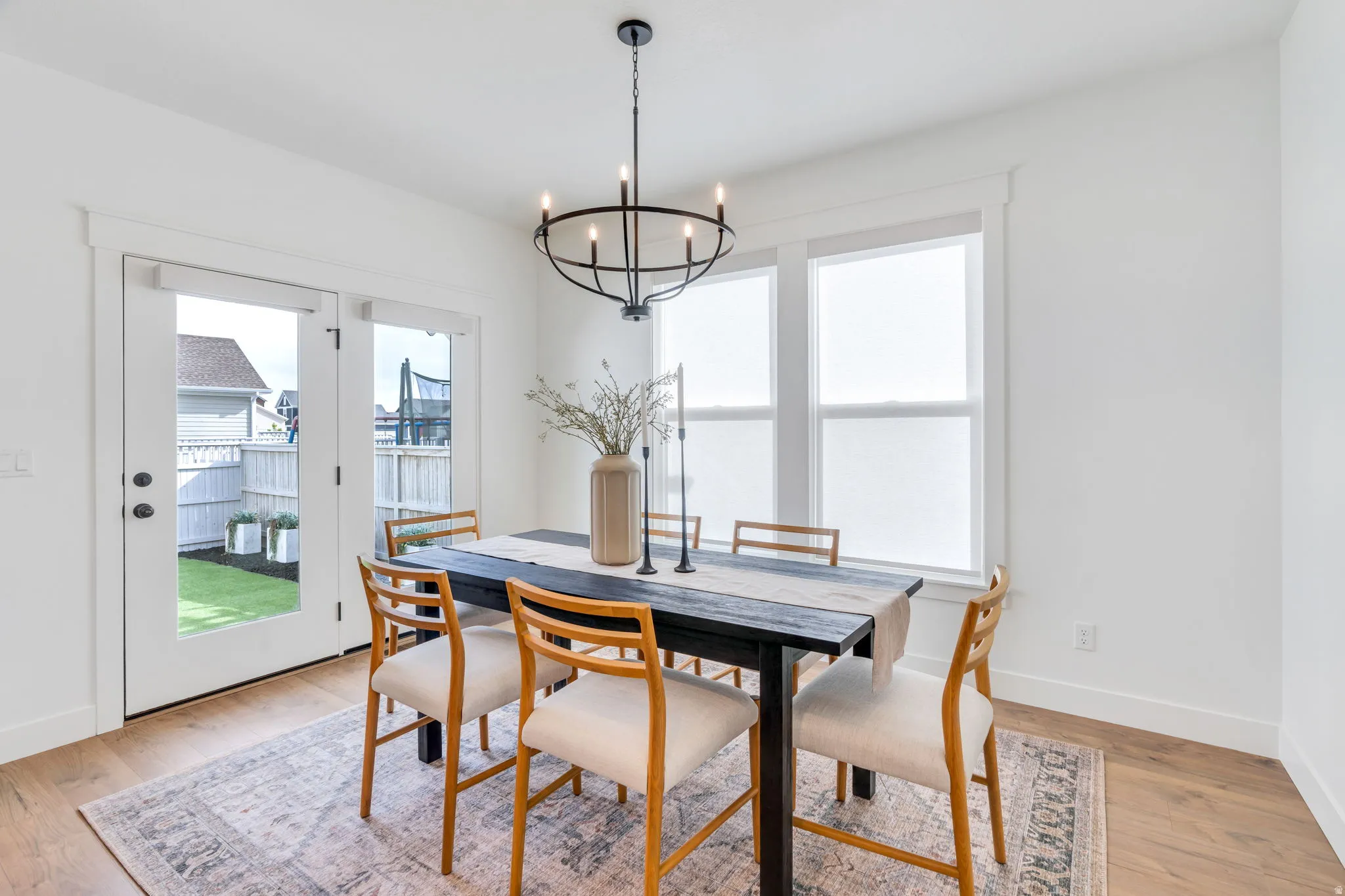 Dining area with light wood-style floors and suspended lighting