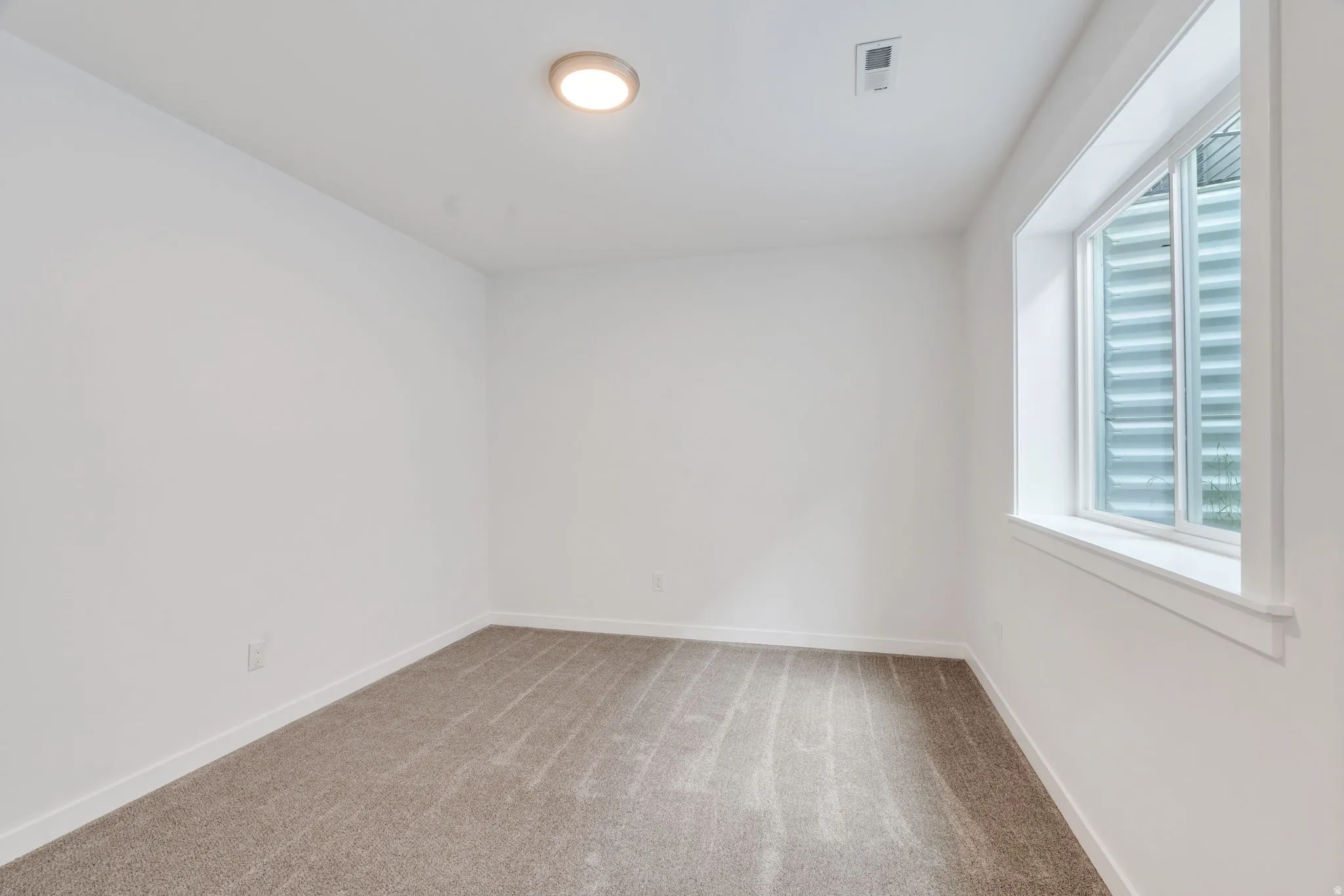 Carpeted empty room with baseboards