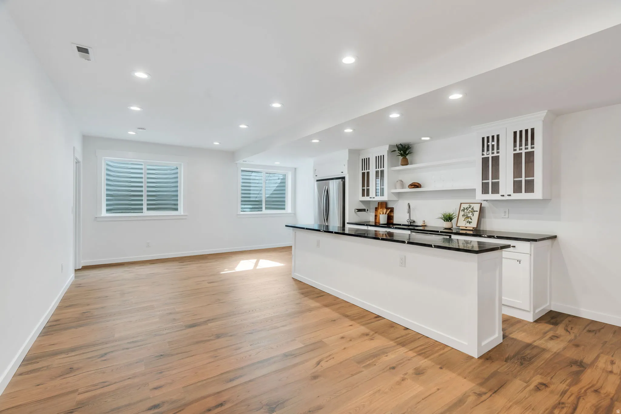 Kitchen with open shelves, white cabinets, glass fronted cabinets, light wood-style floors, and recessed lighting