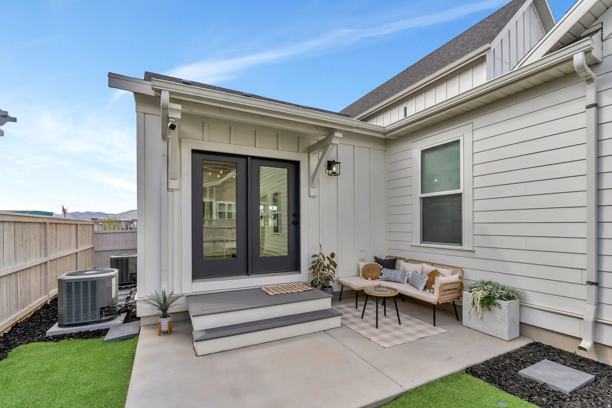 Doorway to property featuring board and batten siding, french doors, roof with shingles, a patio, and an outdoor lounge area