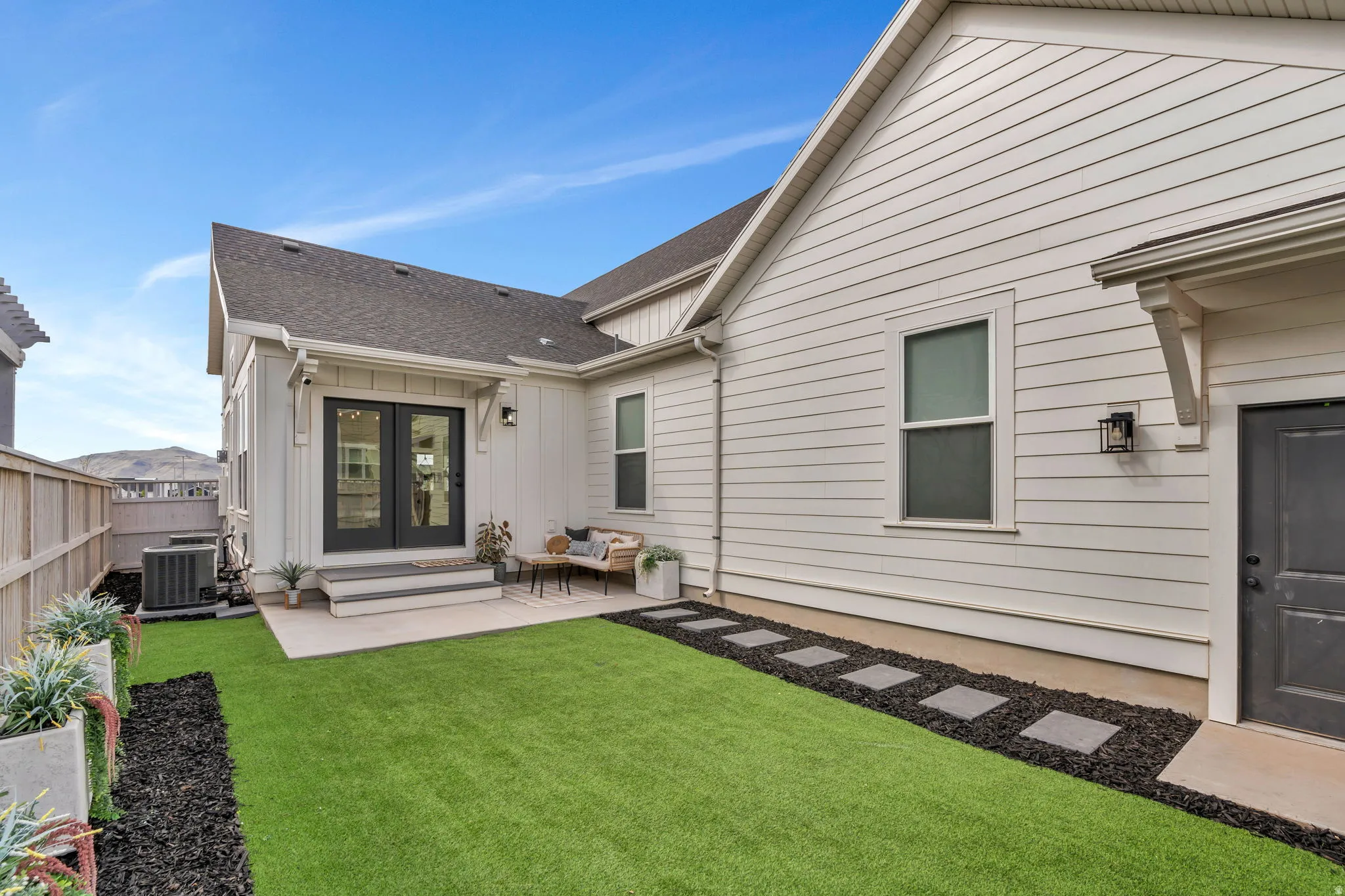 Rear view of property featuring french doors, a patio, roof with shingles, and board and batten siding