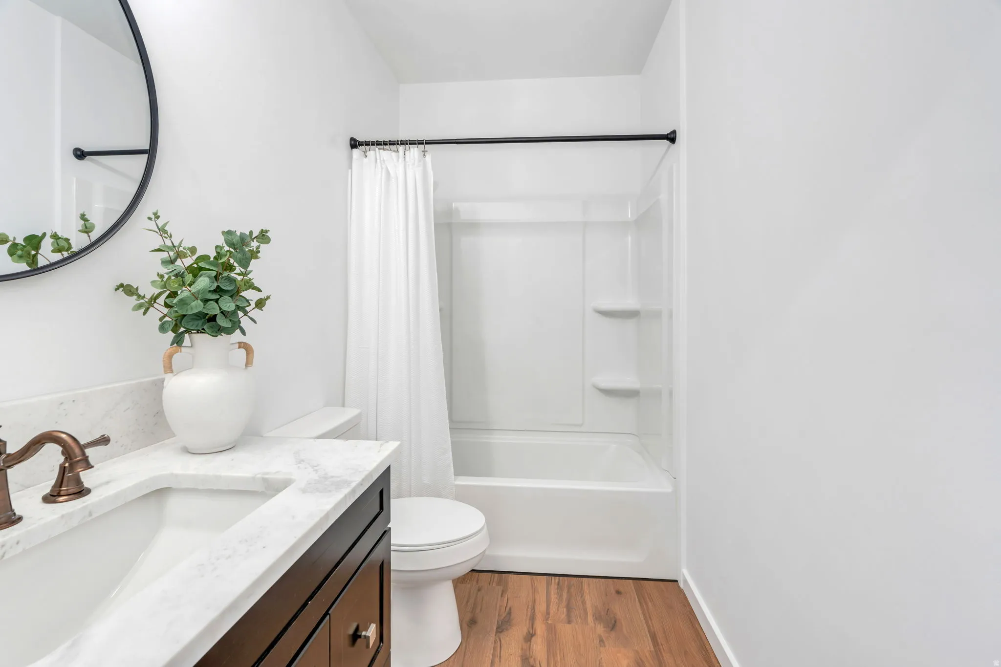 Full bath with vanity, light wood-style floors, and shower / bath combo