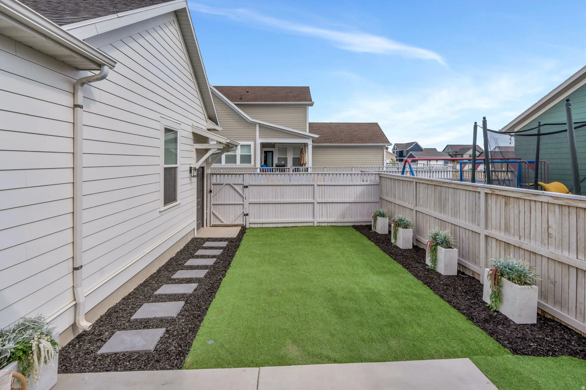 Fenced backyard featuring a residential view and a gate