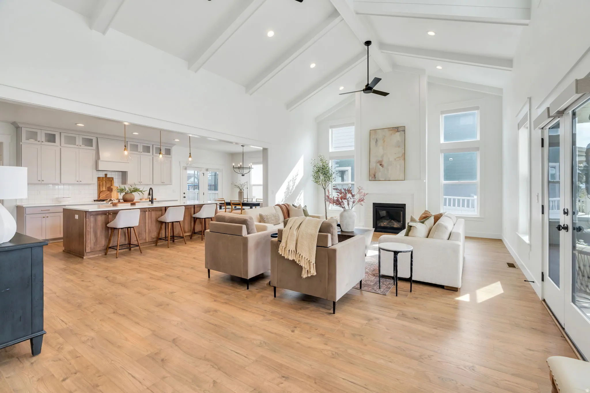 Living area with light wood finished floors, recessed lighting, a large fireplace, and french doors