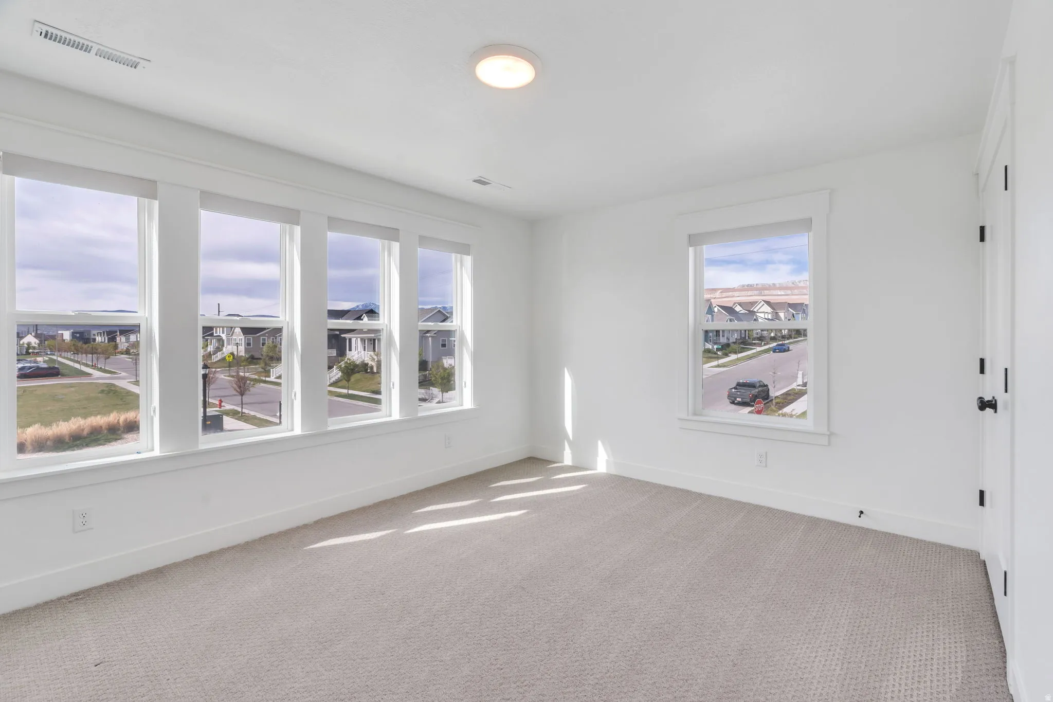 Unfurnished room with light colored carpet and baseboards